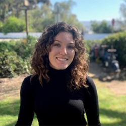 Headshot of Kendall Branton in a black turtleneck, outside.