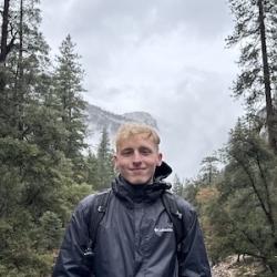 Photo of Donovan Lee hiking in foggy woods.