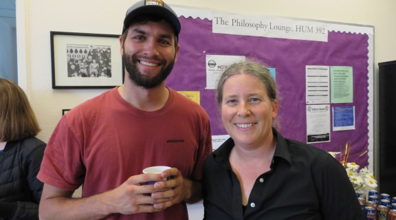 A smiling student and professor.